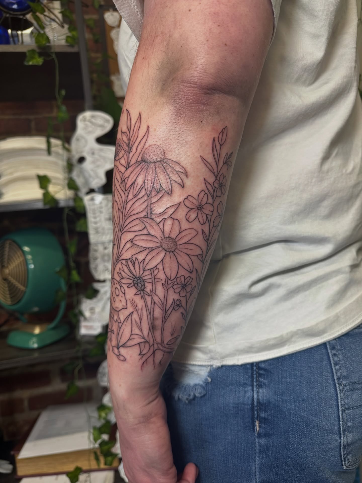 Floral arrangement fine line tattoo on the forearm by Lauren