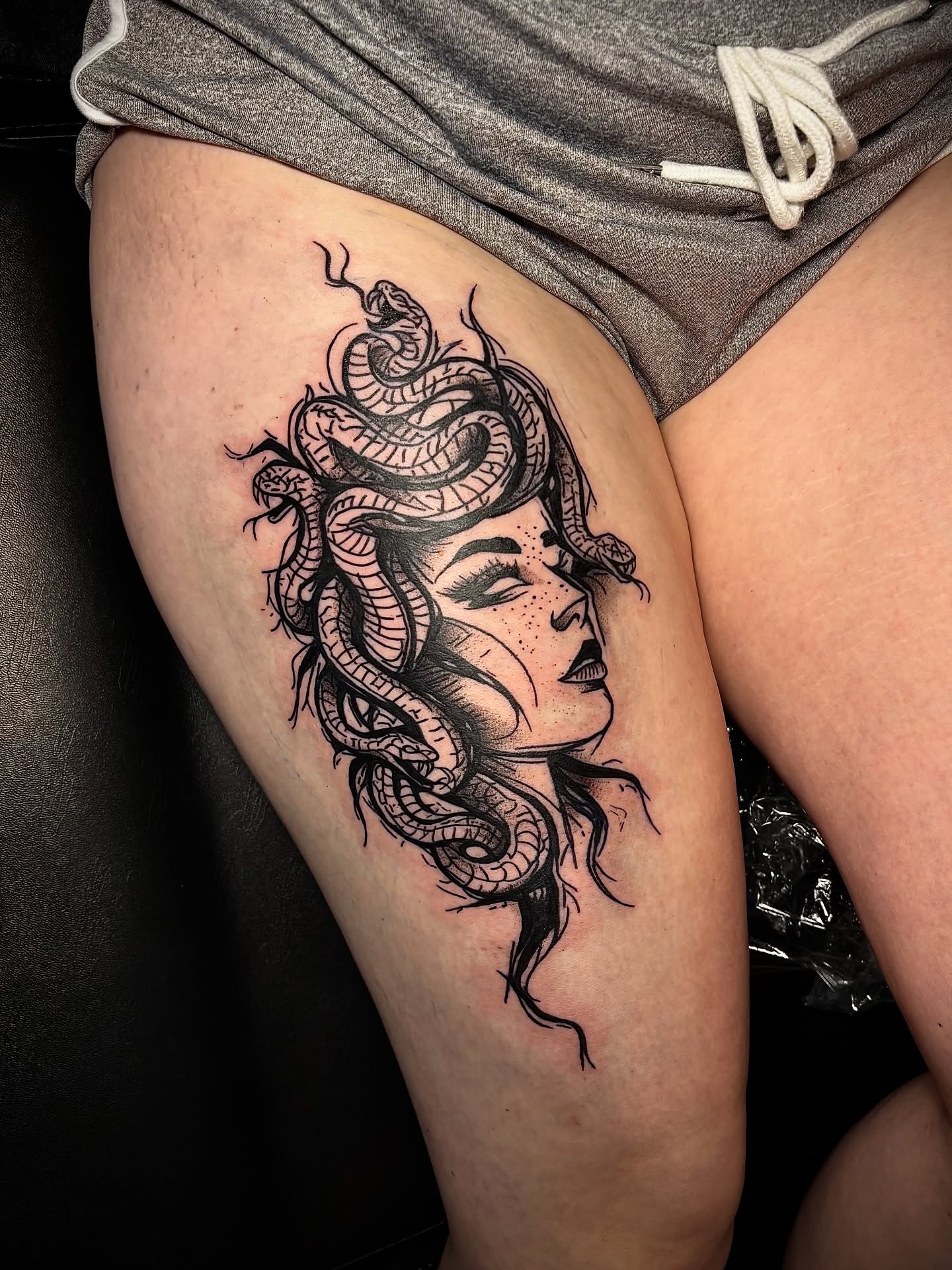 Woman with snakes black and grey tattoo on the thigh by JT.tattoos