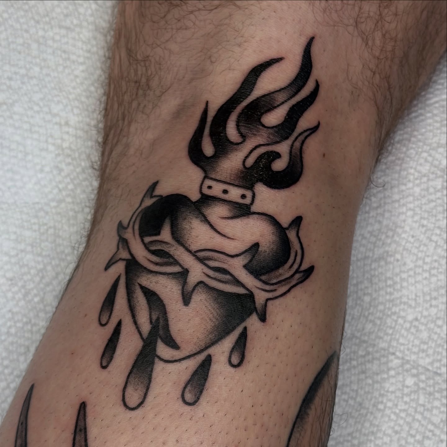 Heart with flames black and grey tattoo on the forearm by Caity