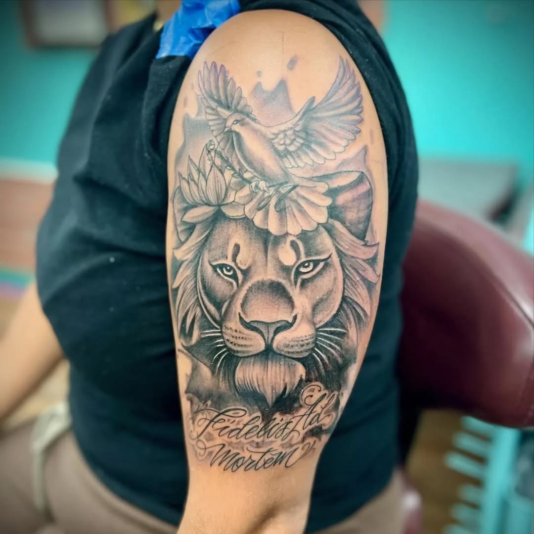 Lion and dove with script Chicano tattoo on the forearm by Watson Gutkowski
