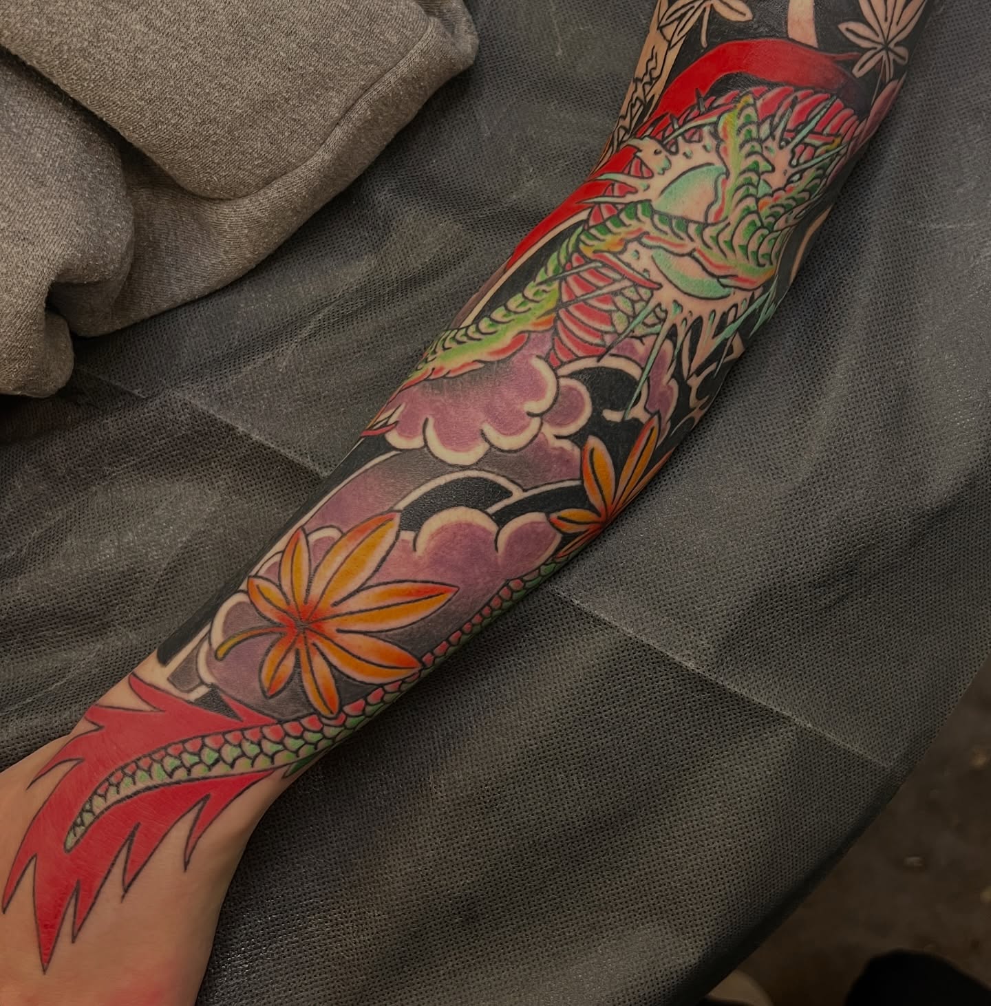Dragon and floral motifs japanese irezumi tattoo on the forearm by Andrea Patterson