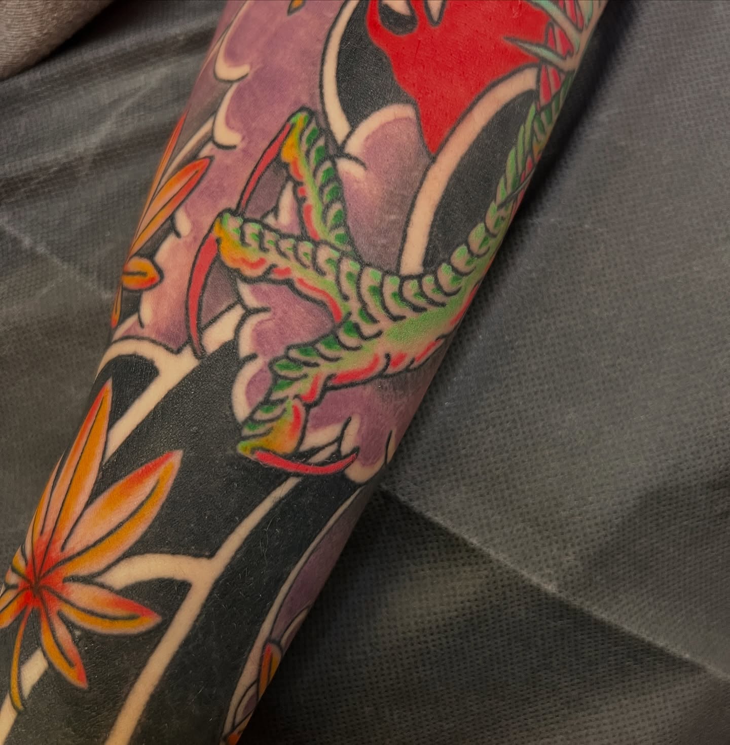 Snake and peony American traditional tattoo on the forearm by Andrea Patterson