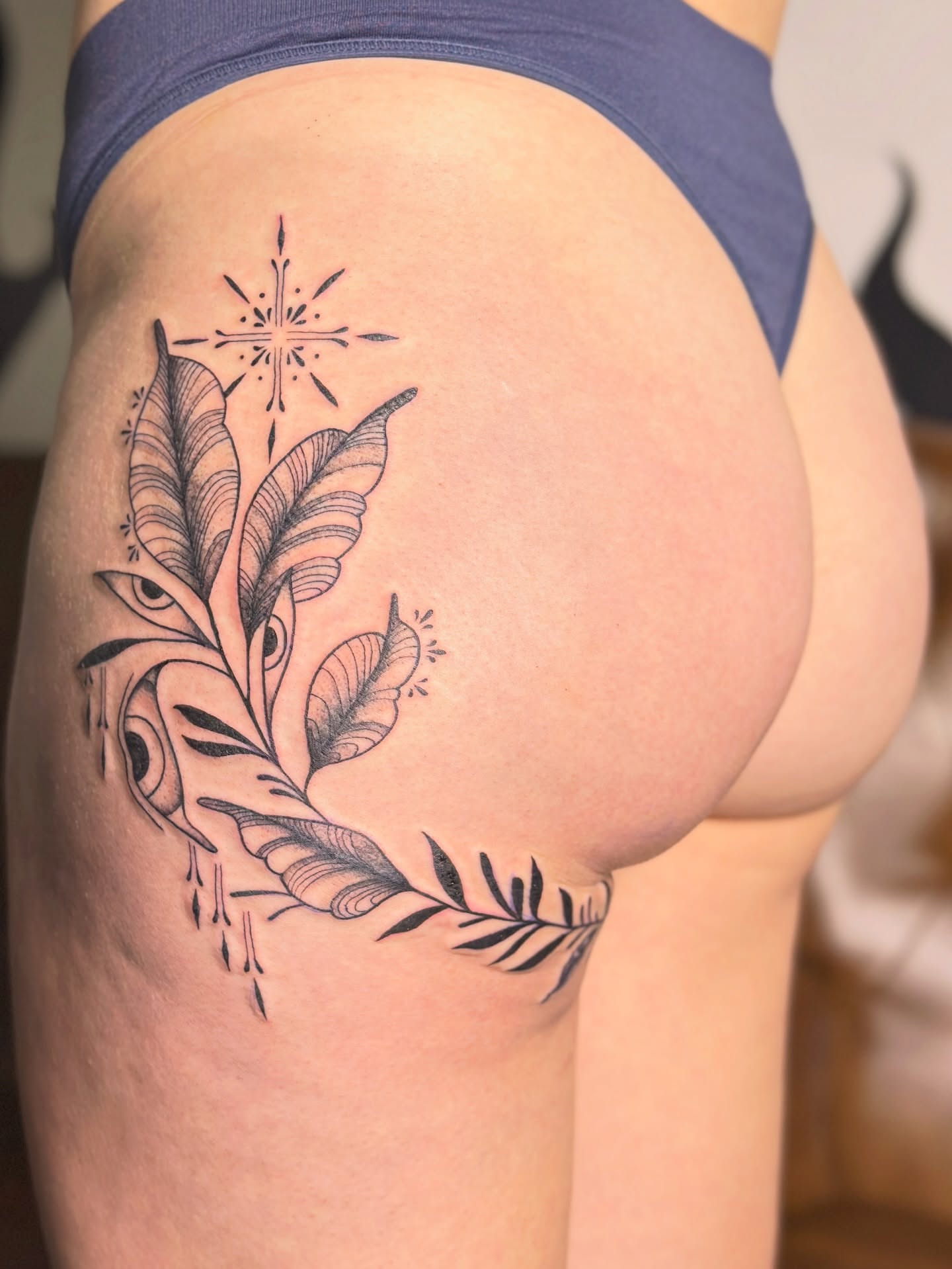 Feather and eye geometric tattoo on the thigh by Hayley Thomas