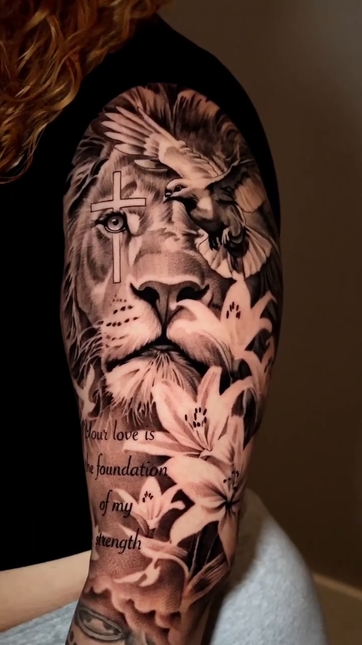 Lion with lilies and cross Chicano tattoo on the upper arm by Jesus Bravo