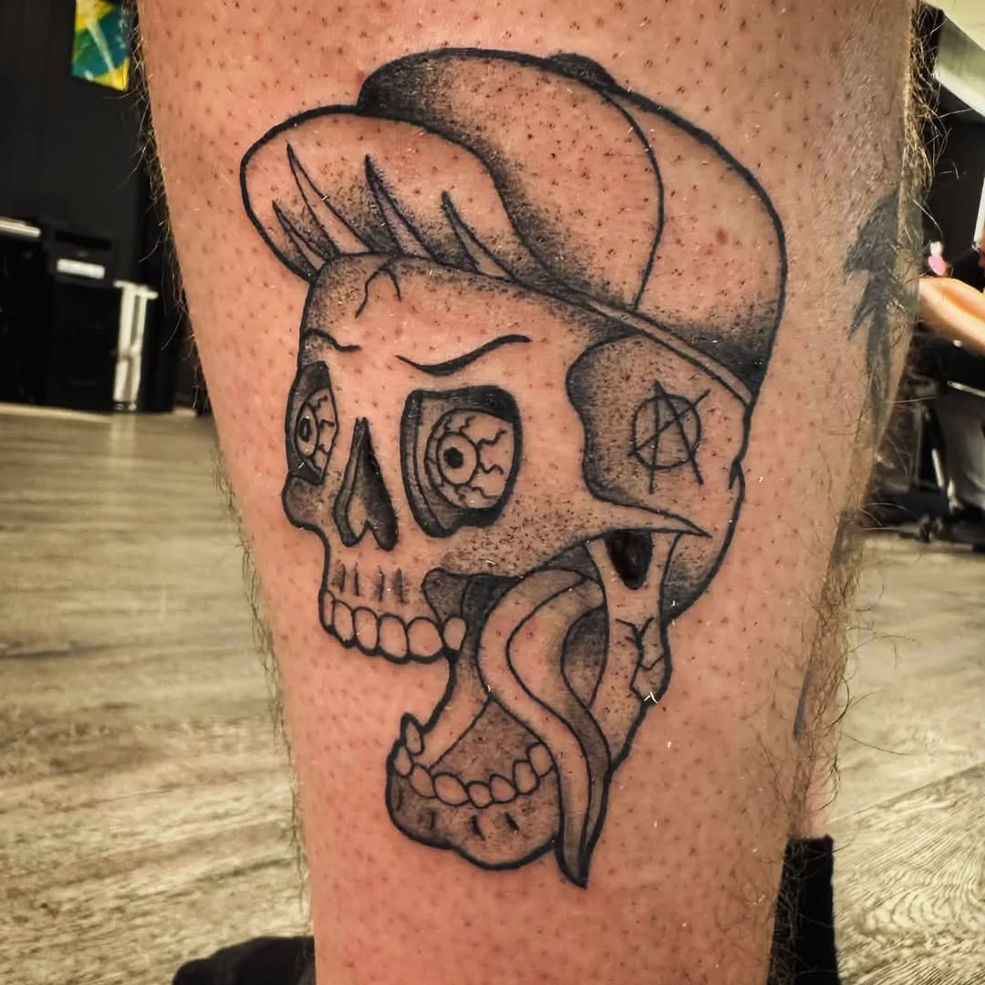 Skull with tongue and hat realism tattoo on the thigh by Matt Mahl