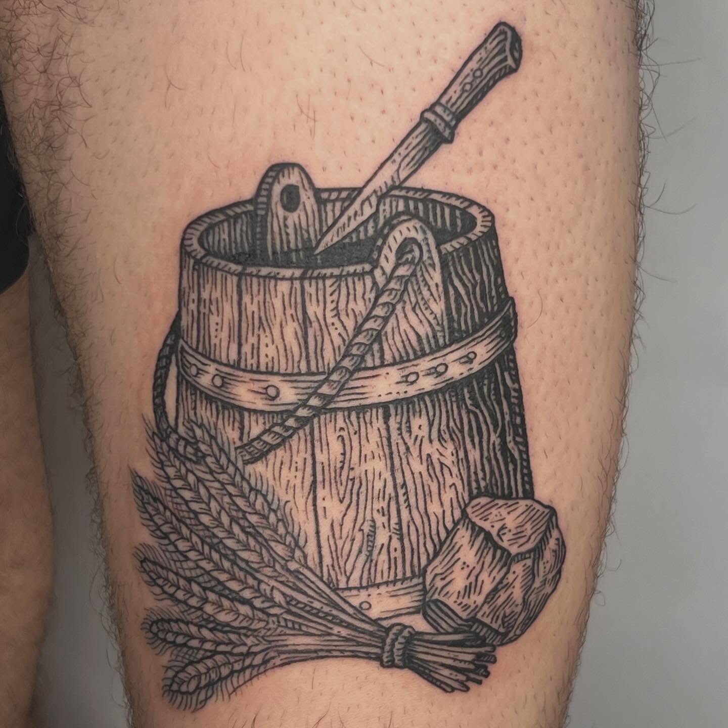 Wooden bucket black and grey tattoo on the thigh by Jason Middelton