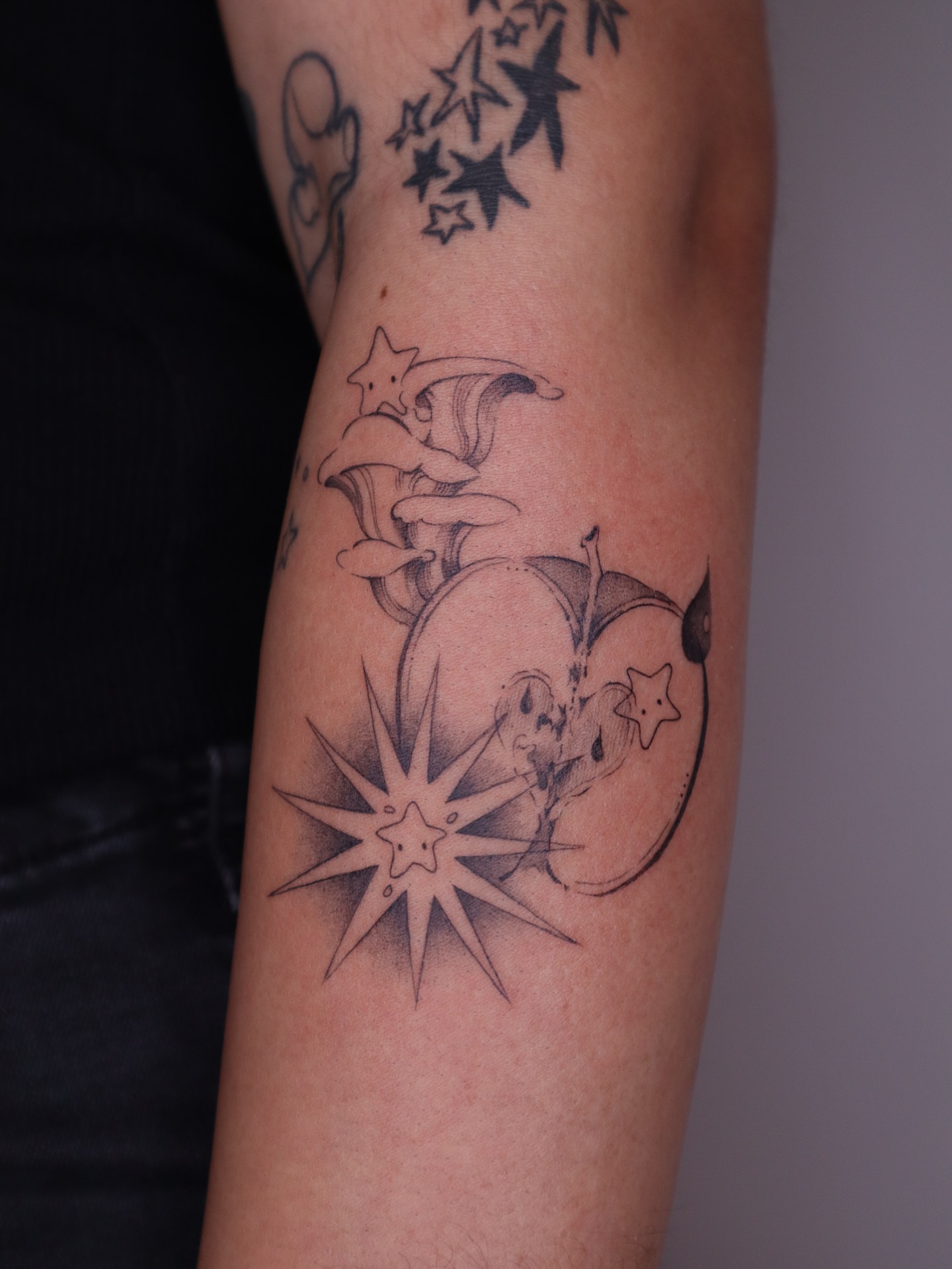 Moon and stars black and grey tattoo on the forearm by Savana Wang