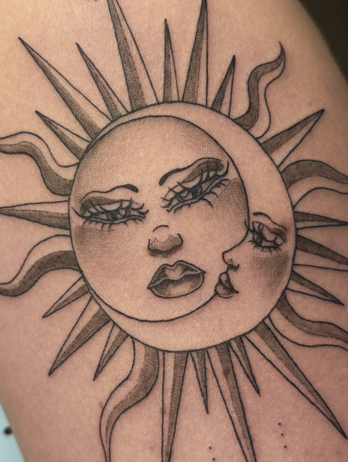 Sun face realism tattoo on the shoulder by Fine Line Tattoo Artist