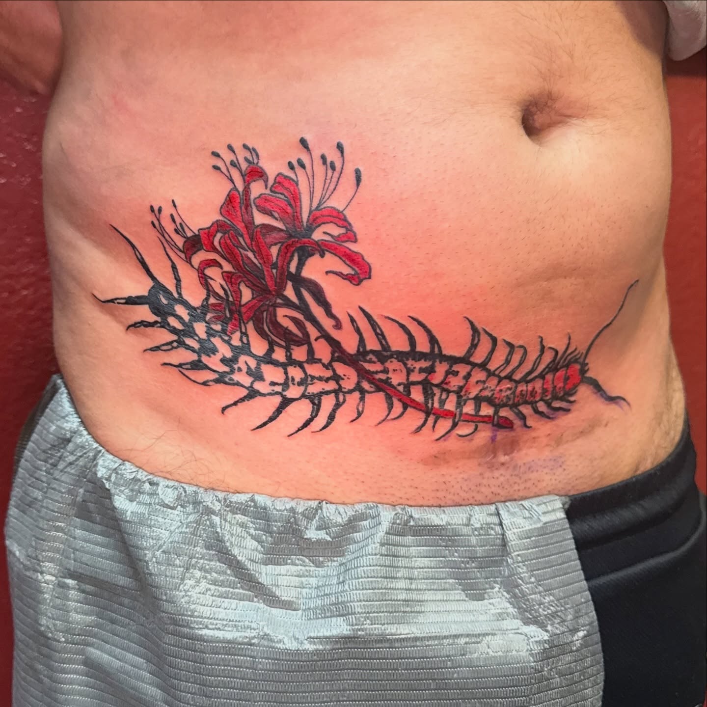 Centipede and flowers American traditional tattoo on the ribs by Nick Weaver
