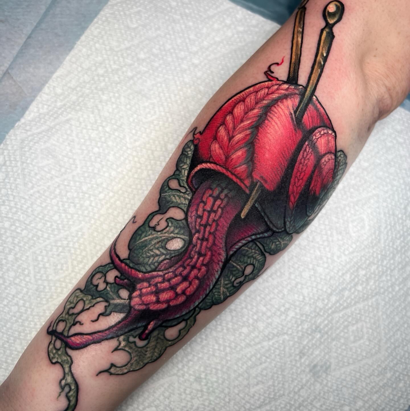 Snail and flower realism tattoo on the forearm by Kate Erso
