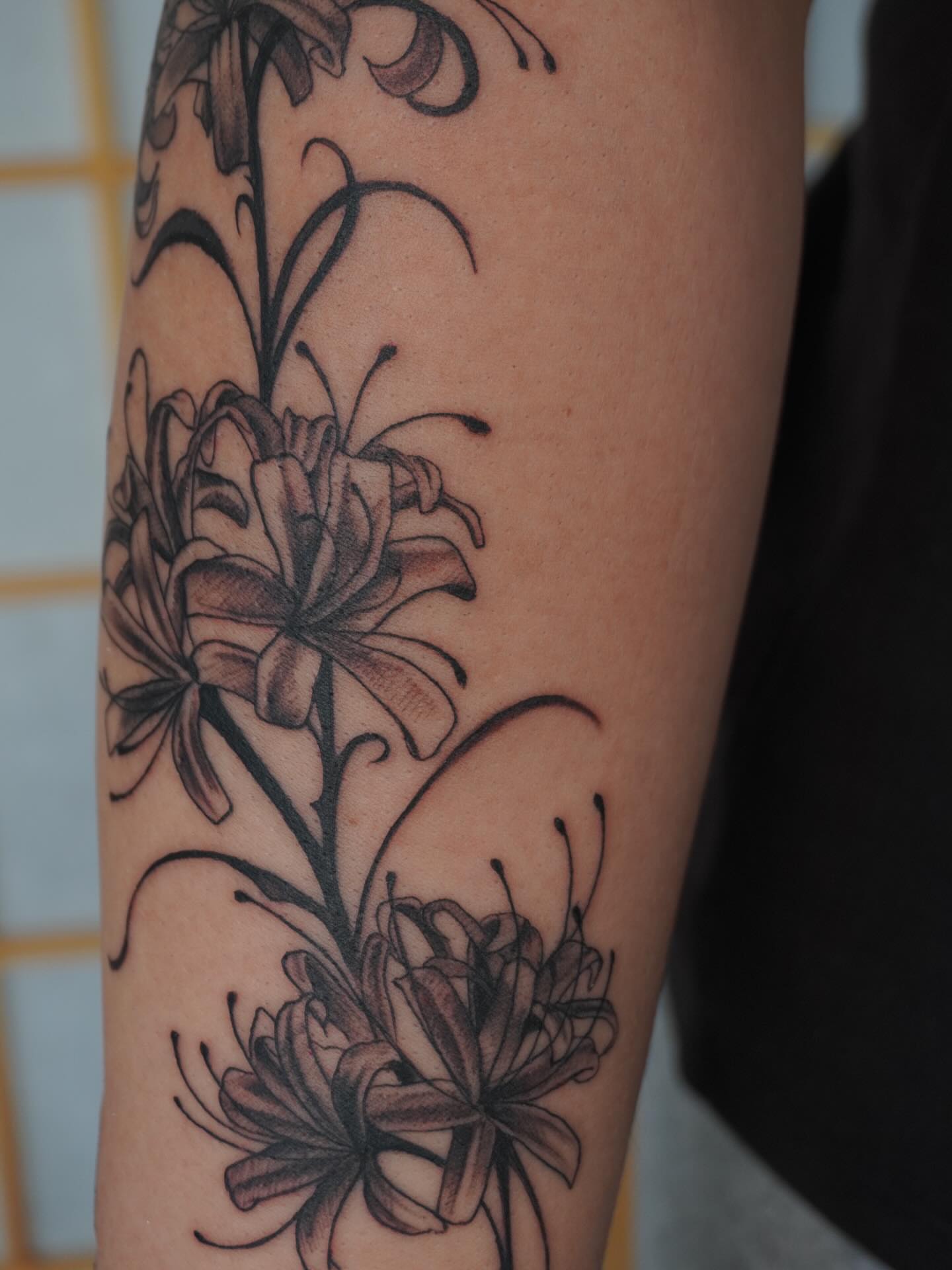 Lilies black and grey tattoo on the forearm by hallow ☣︎ tattoo artist, Philadelphia, Pennsylvania