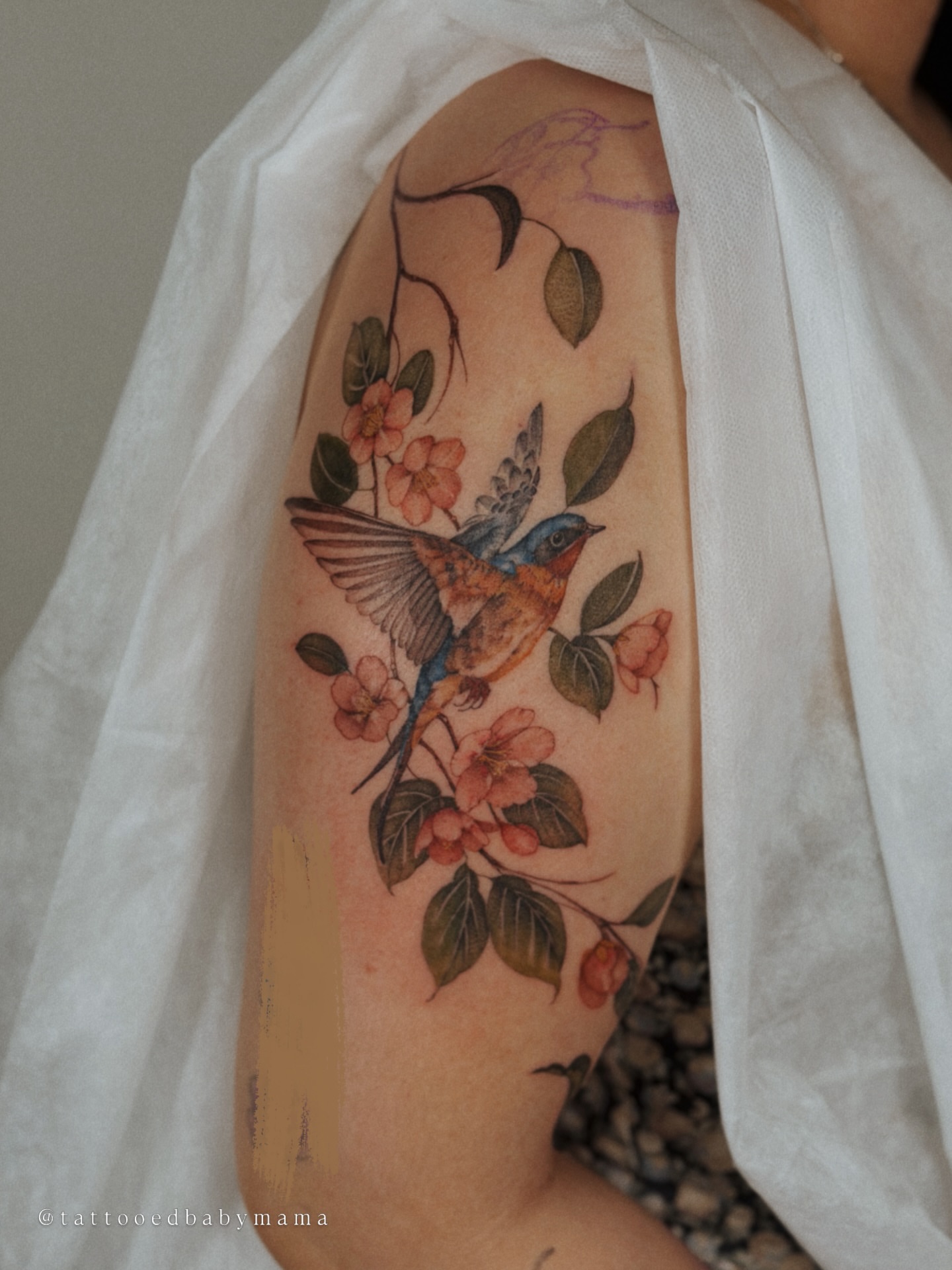 Bird and flowers watercolor tattoo on the forearm by Andrea Evangelista