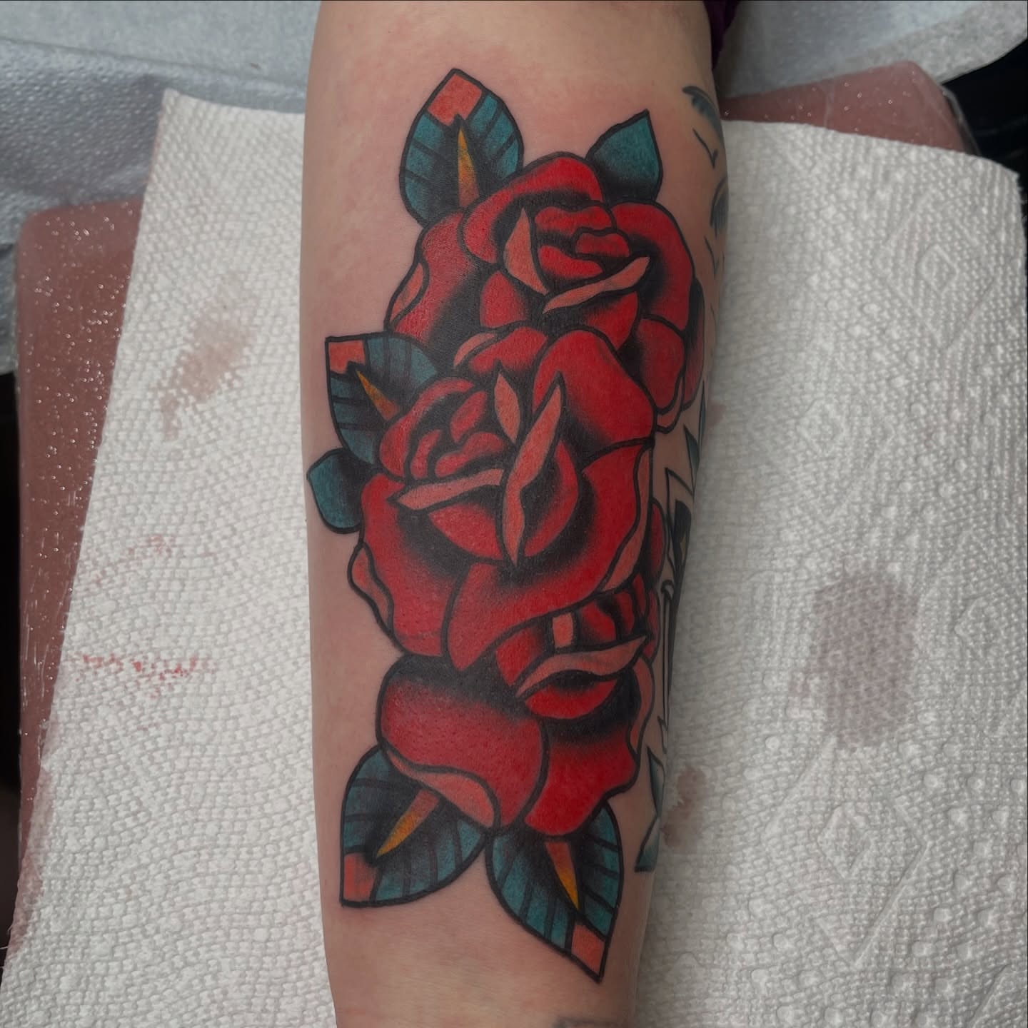 Red roses American traditional tattoo on the forearm by Chris Martin
