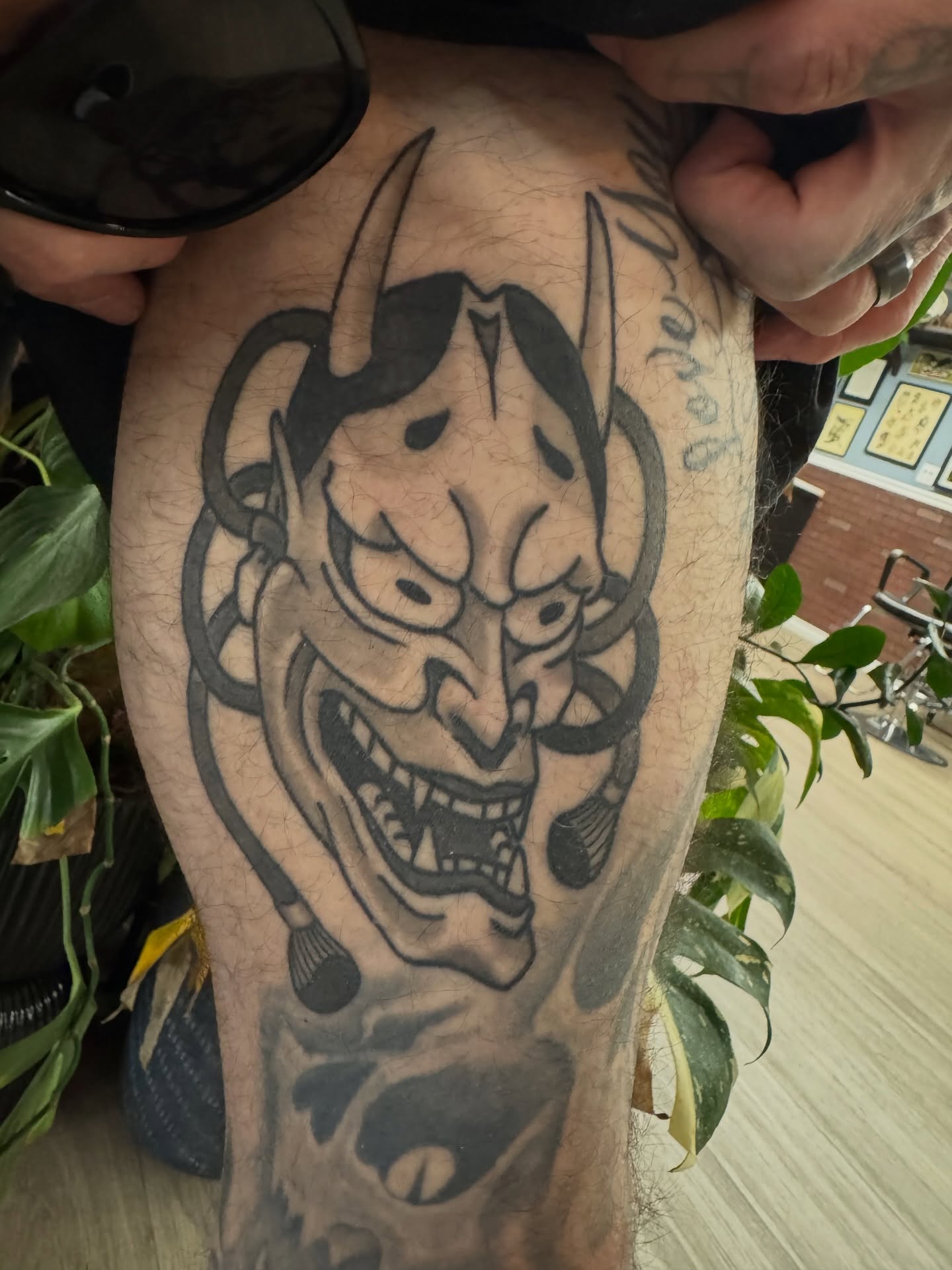 Demon mask black and grey tattoo on the forearm by Dylan