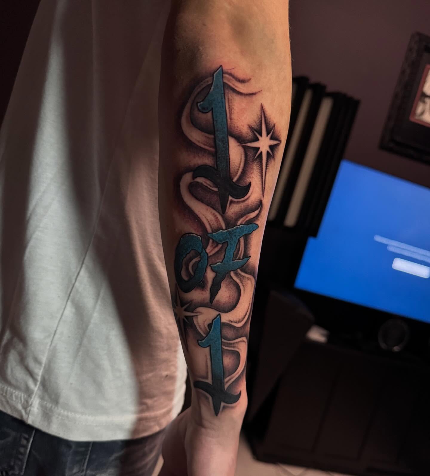 Number and star lettering script tattoo on the forearm by Lindsay