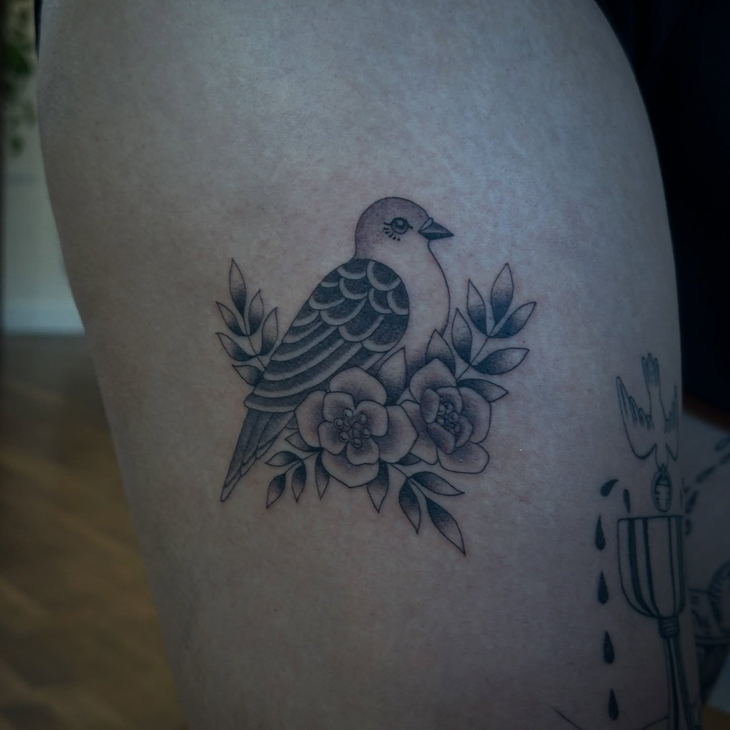 Bird and flowers black and grey tattoo on the thigh by Bree Lin