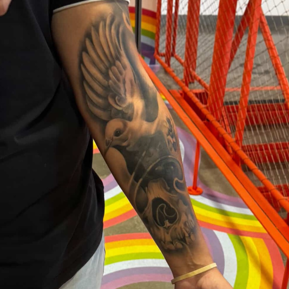 Bird and swirls realism tattoo on the forearm by Angel Pineda-Rodriguez