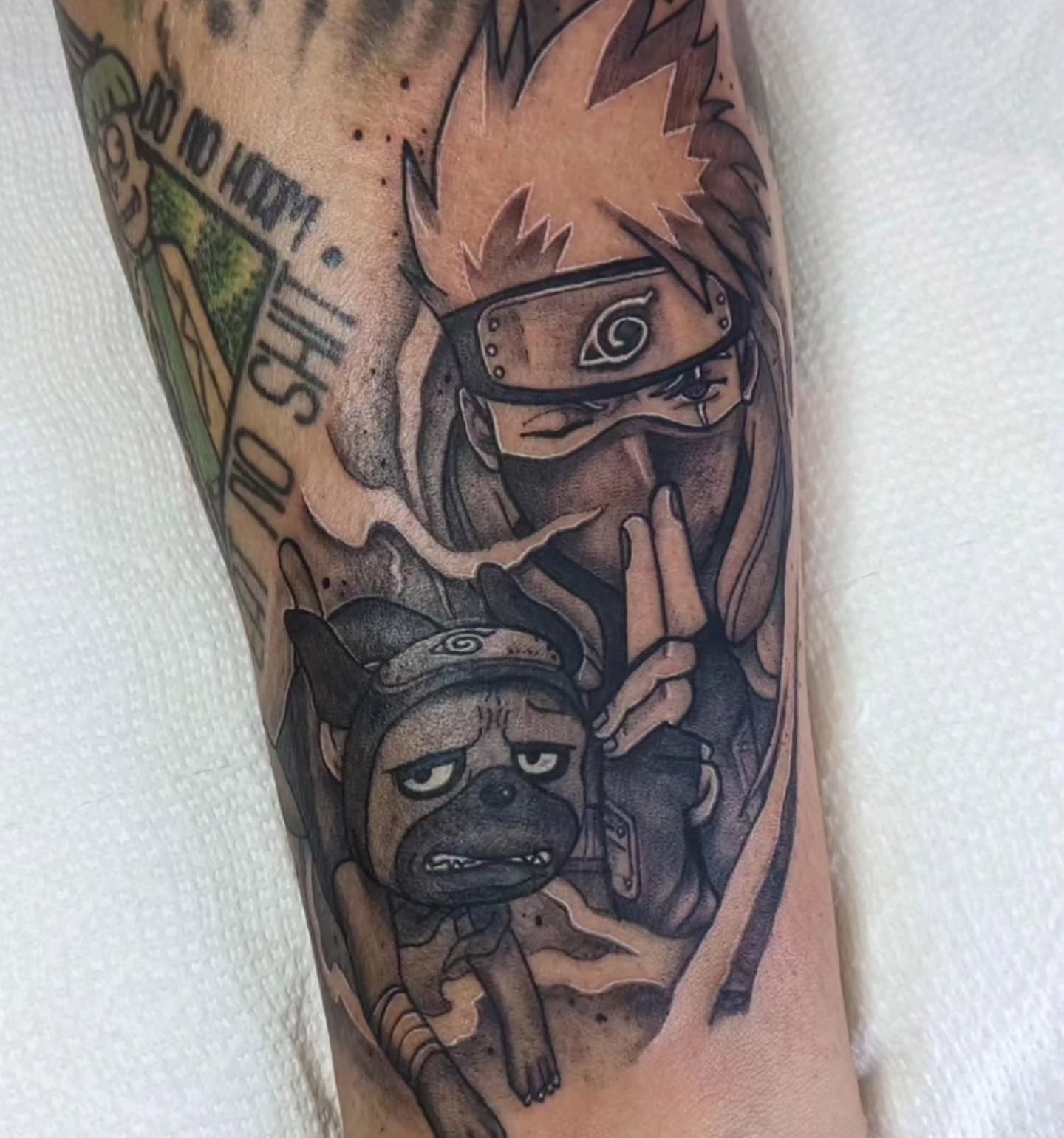Naruto and dog anime tattoo on the forearm by Ed Gonzalez