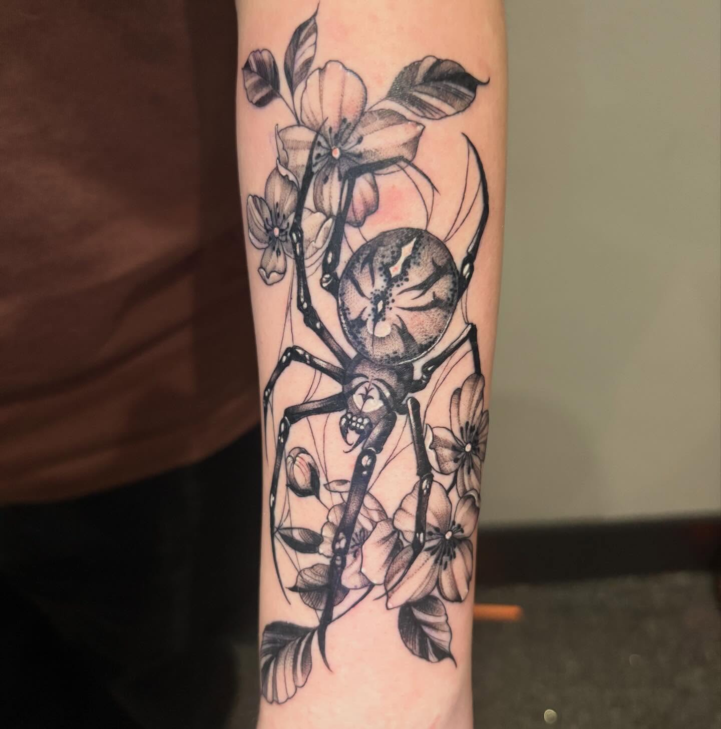 Spider and flowers realism tattoo on the forearm by Eddie Wolfe