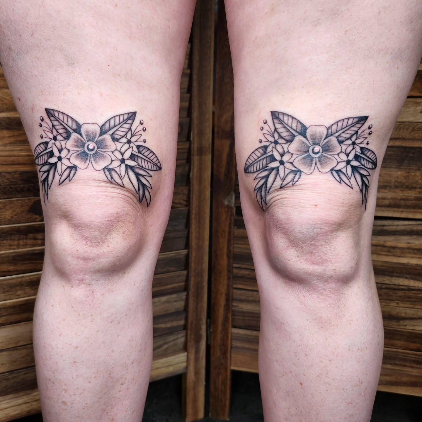Floral arrangement black and grey tattoo on the thigh by Kelly Zito