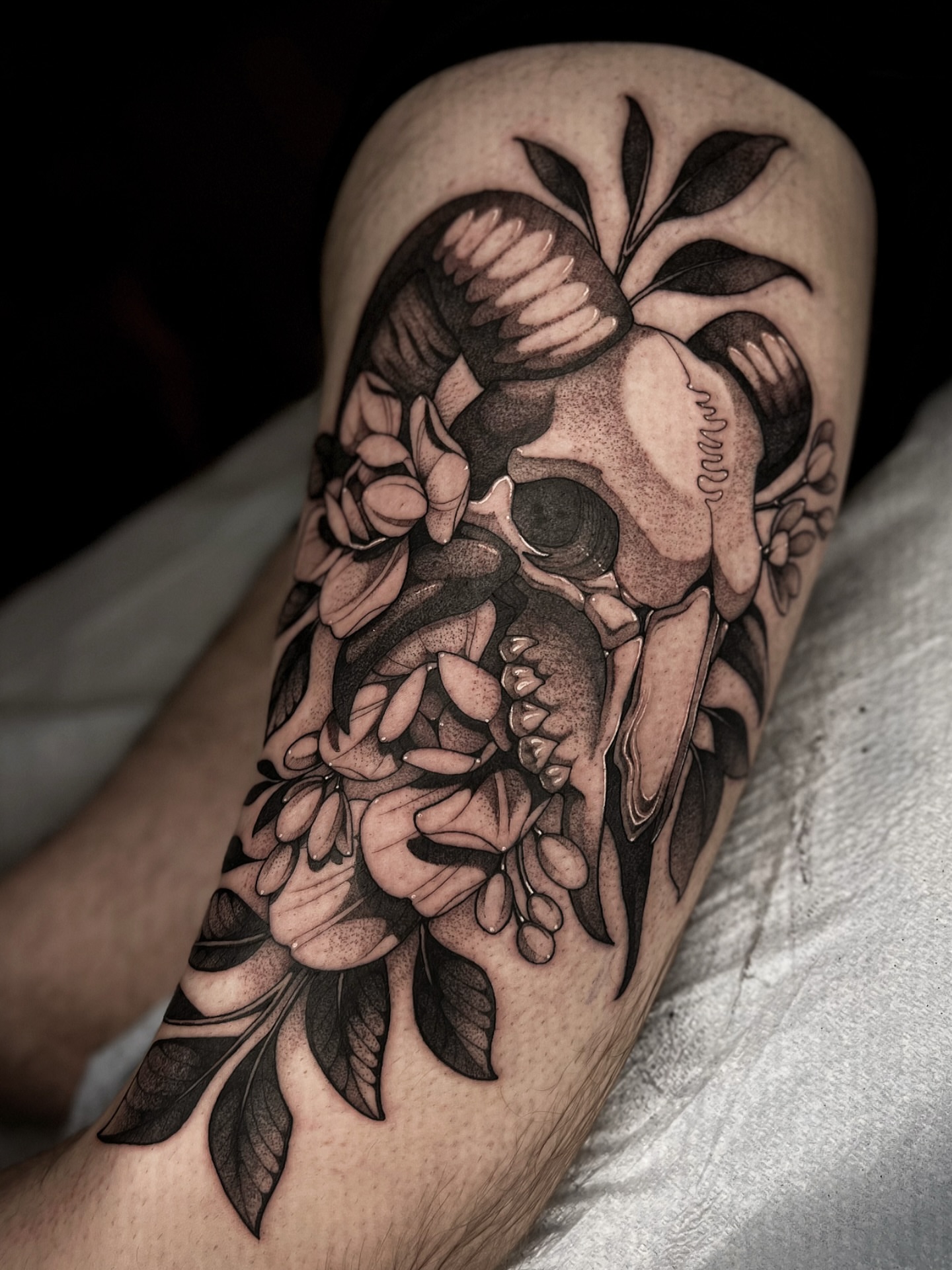 Skull and flowers dotwork tattoo on the forearm by Kaysee Shuster