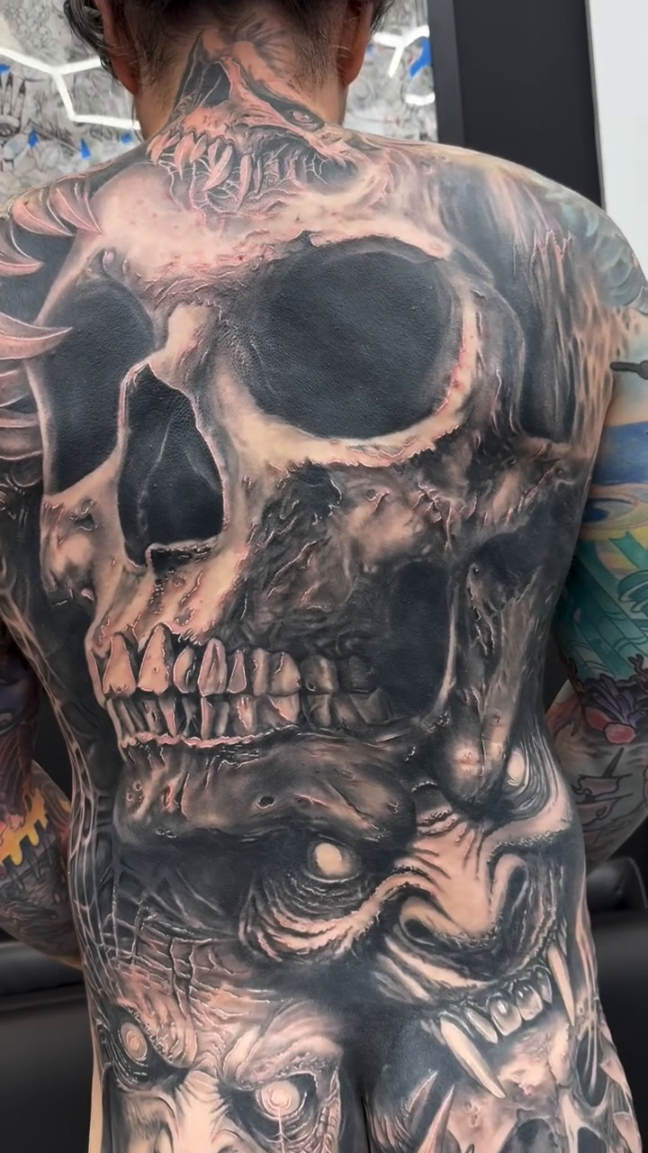 Skull and demonic faces dark realism tattoo by Steve Bishov