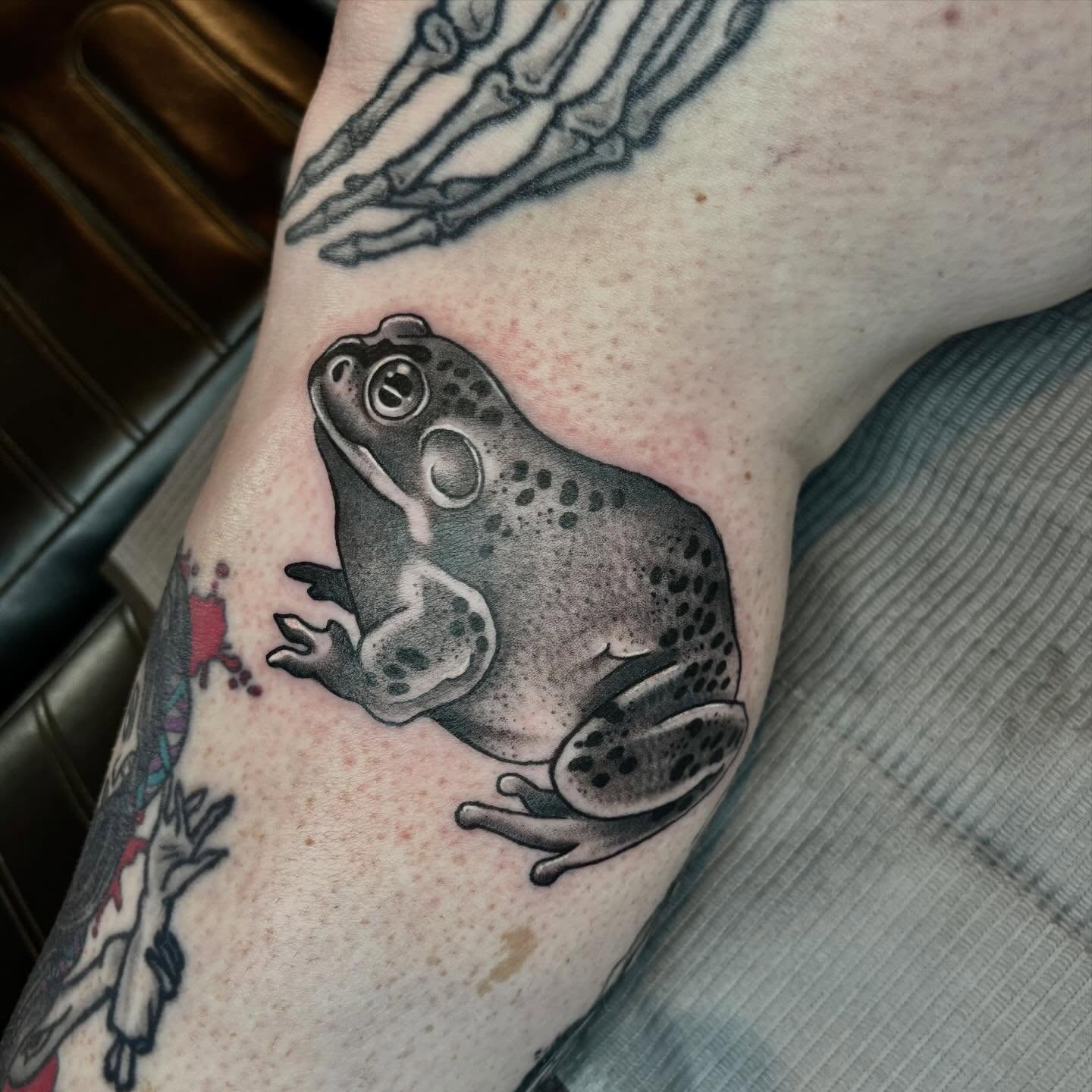 Frog black and grey tattoo on the forearm by Mim
