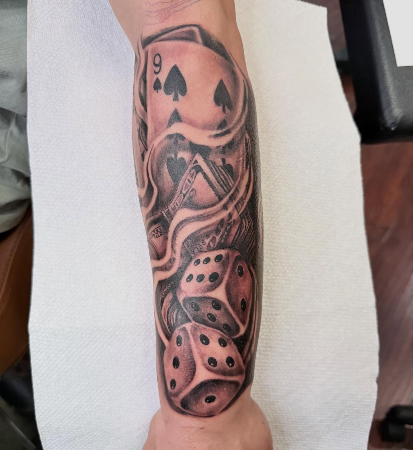 Playing cards and dice realism tattoo on the forearm by Las Vegas Tattoo Artist