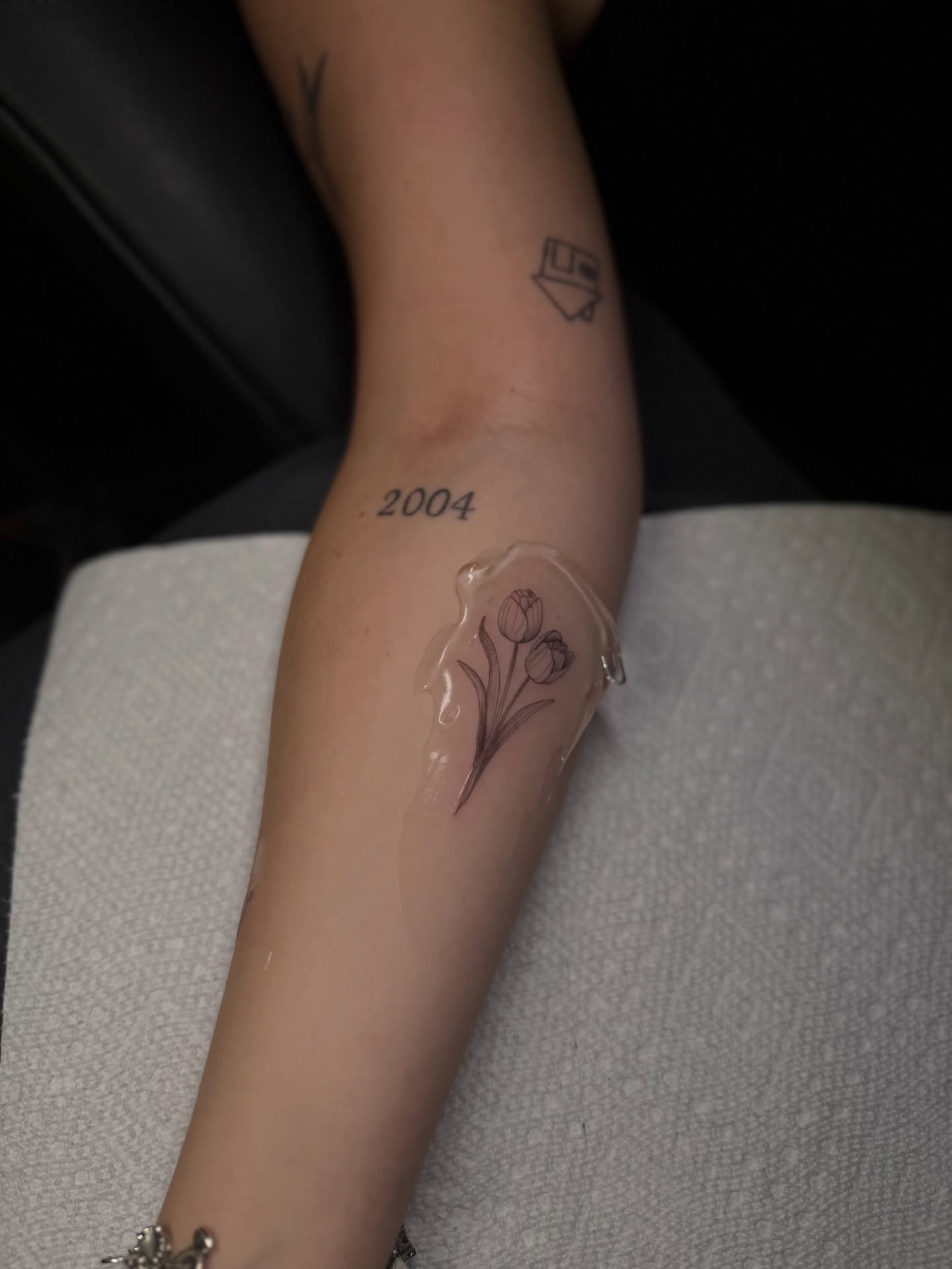 Flowers black and grey tattoo on the forearm by Fineline Tattoos DFW