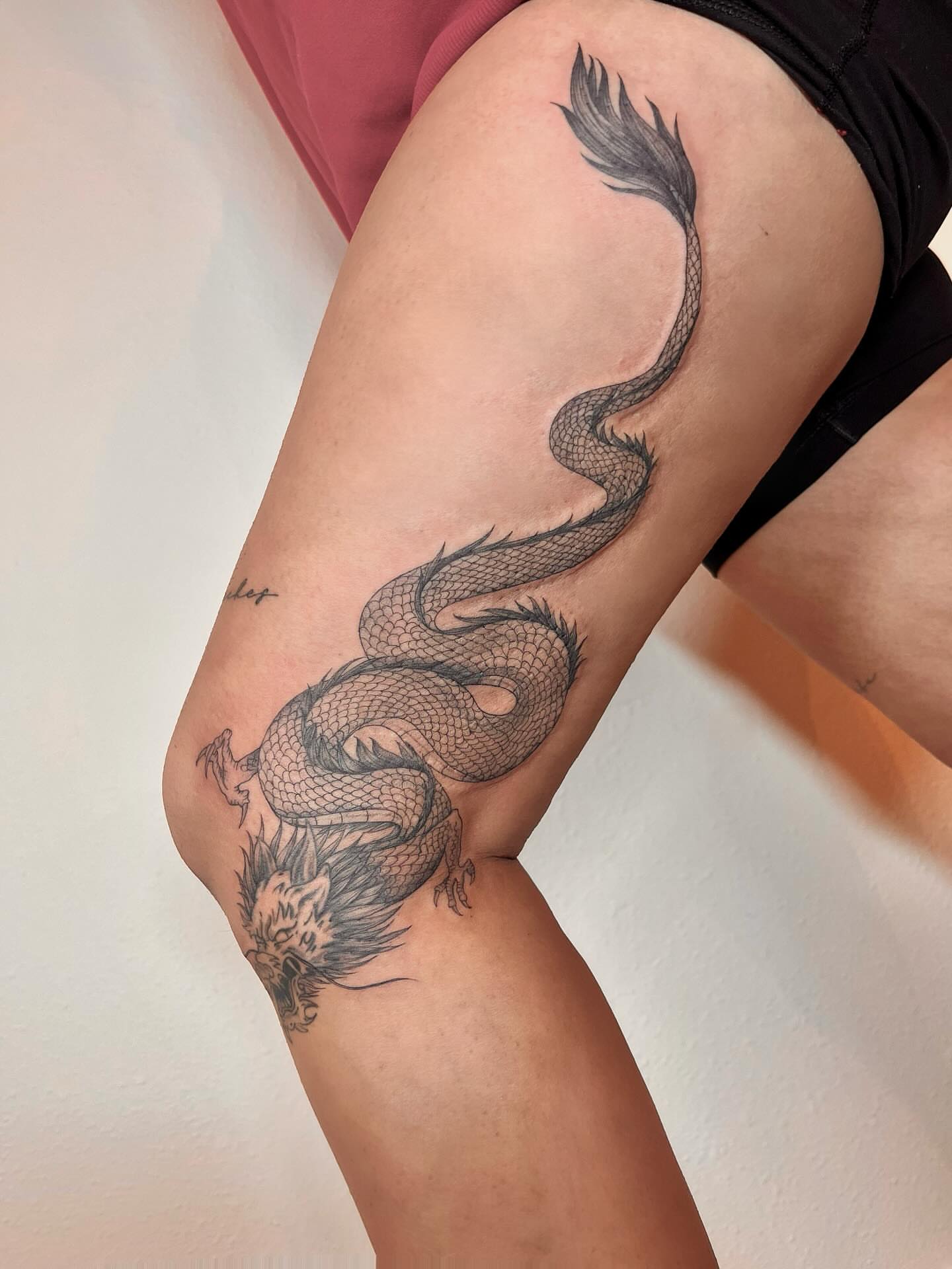 Dragon black and grey tattoo on the thigh by Kite.Tattoo_Amber