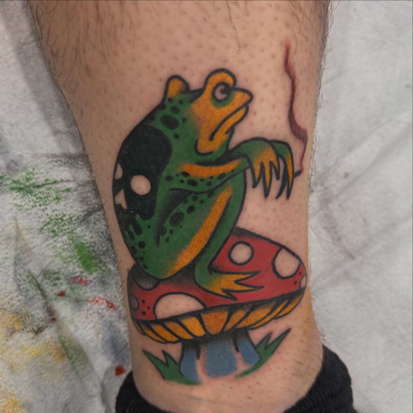 Frog and mushroom American traditional tattoo on the forearm by Kyle Simmons
