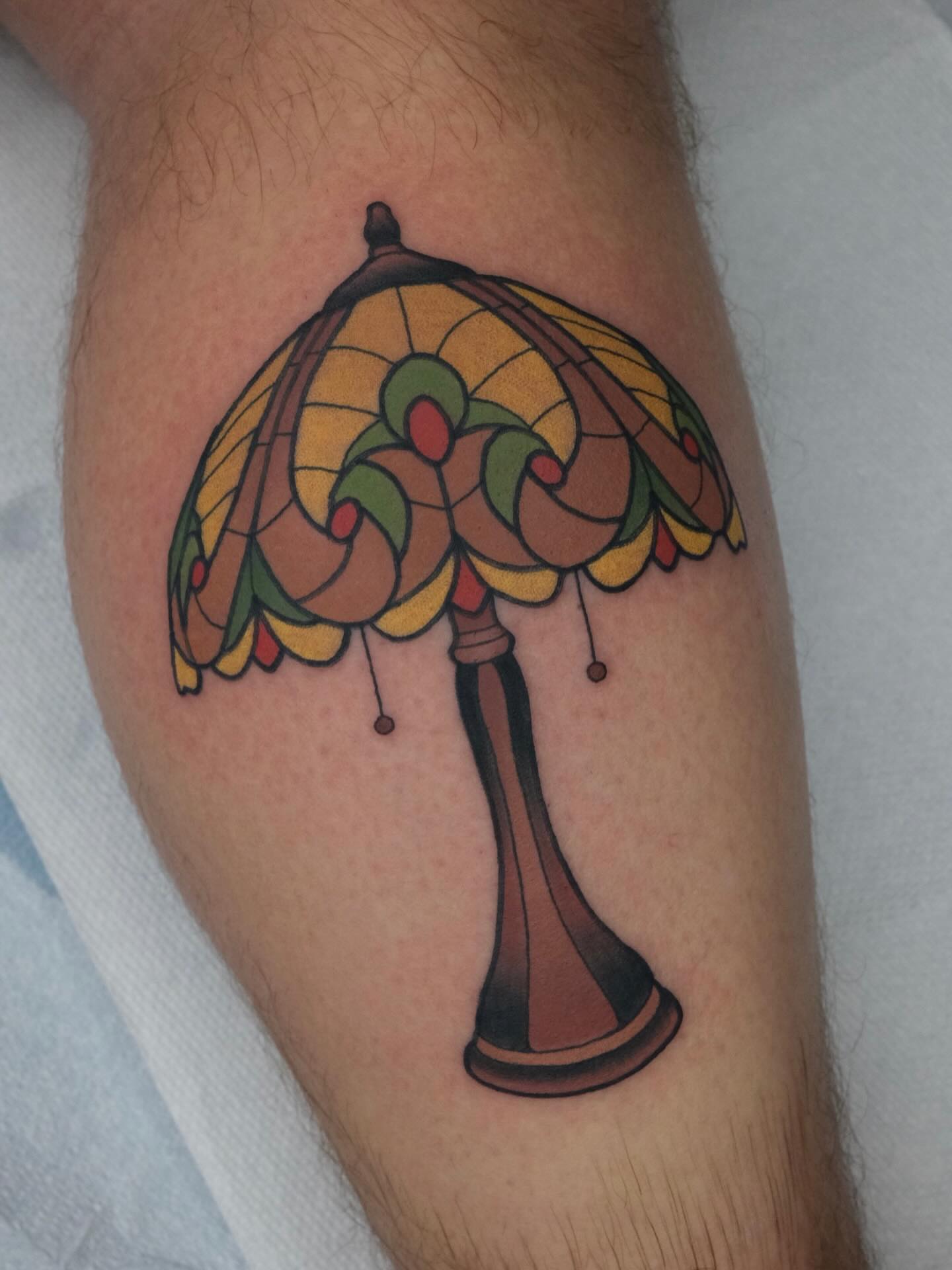 Stained glass lamp new school tattoo on the forearm by James Maxwell