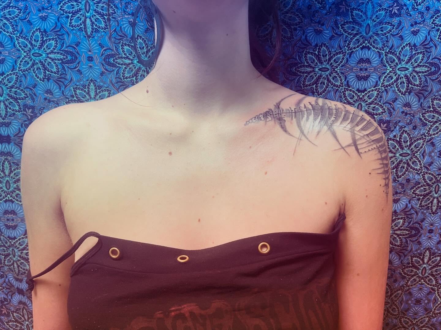 Feather black and grey tattoo on the shoulder by La Main Bleue
