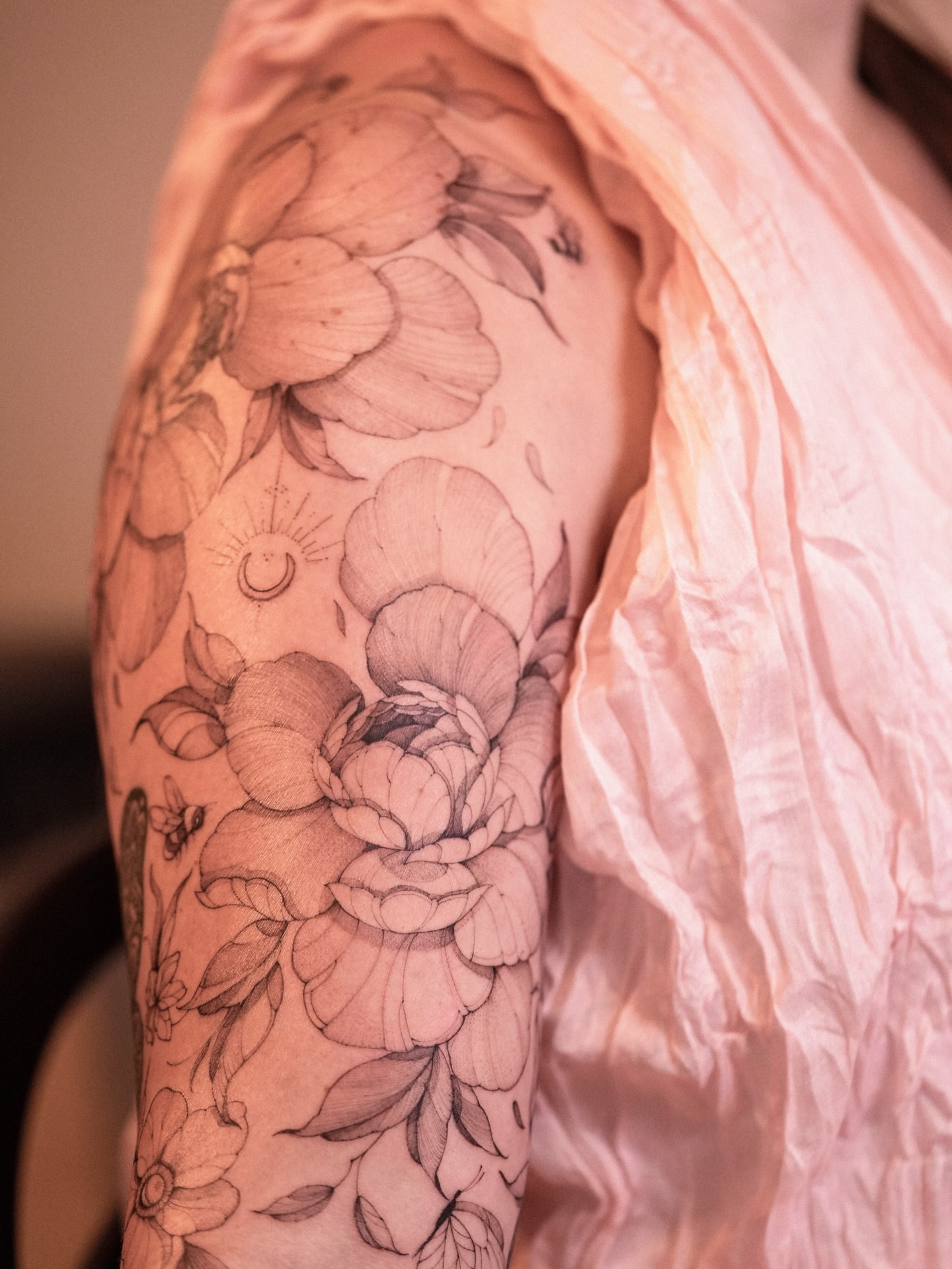 Floral bouquet realism tattoo on the upper arm by Zalina Loriia