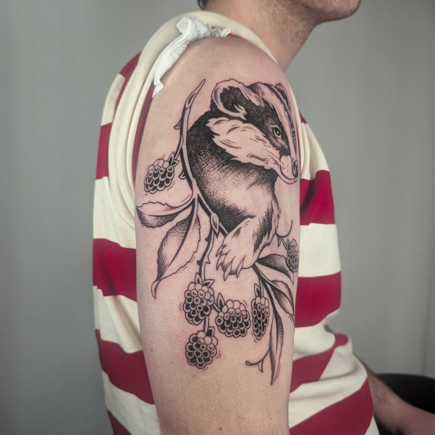 Badger and blackberries black and grey tattoo on the forearm by Courtney Yaddof