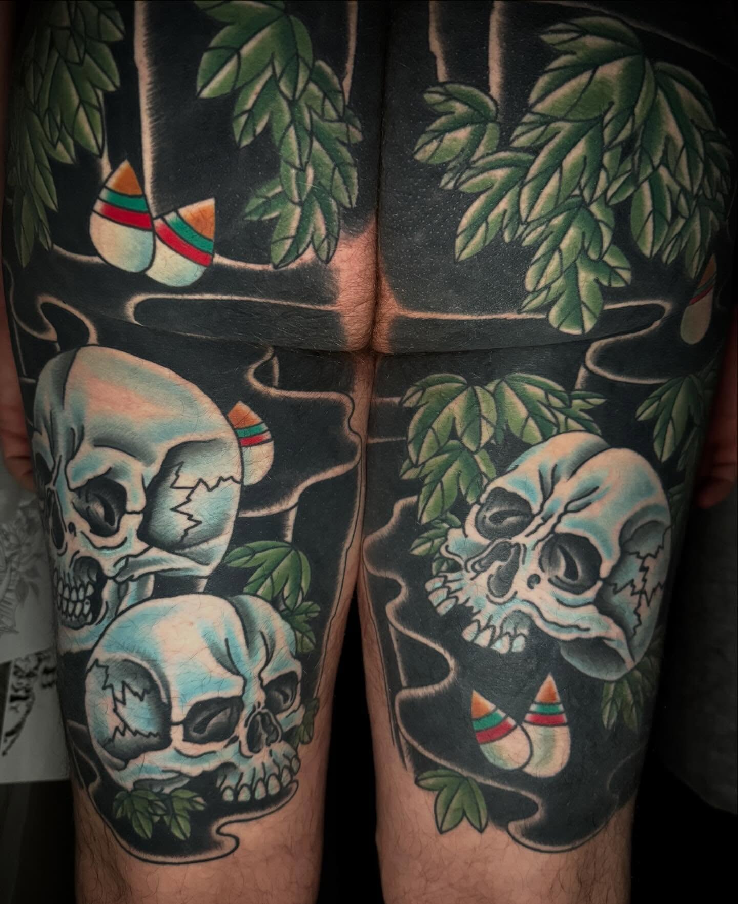 Skulls and leaves American traditional tattoo on the thigh by Mike Diamond