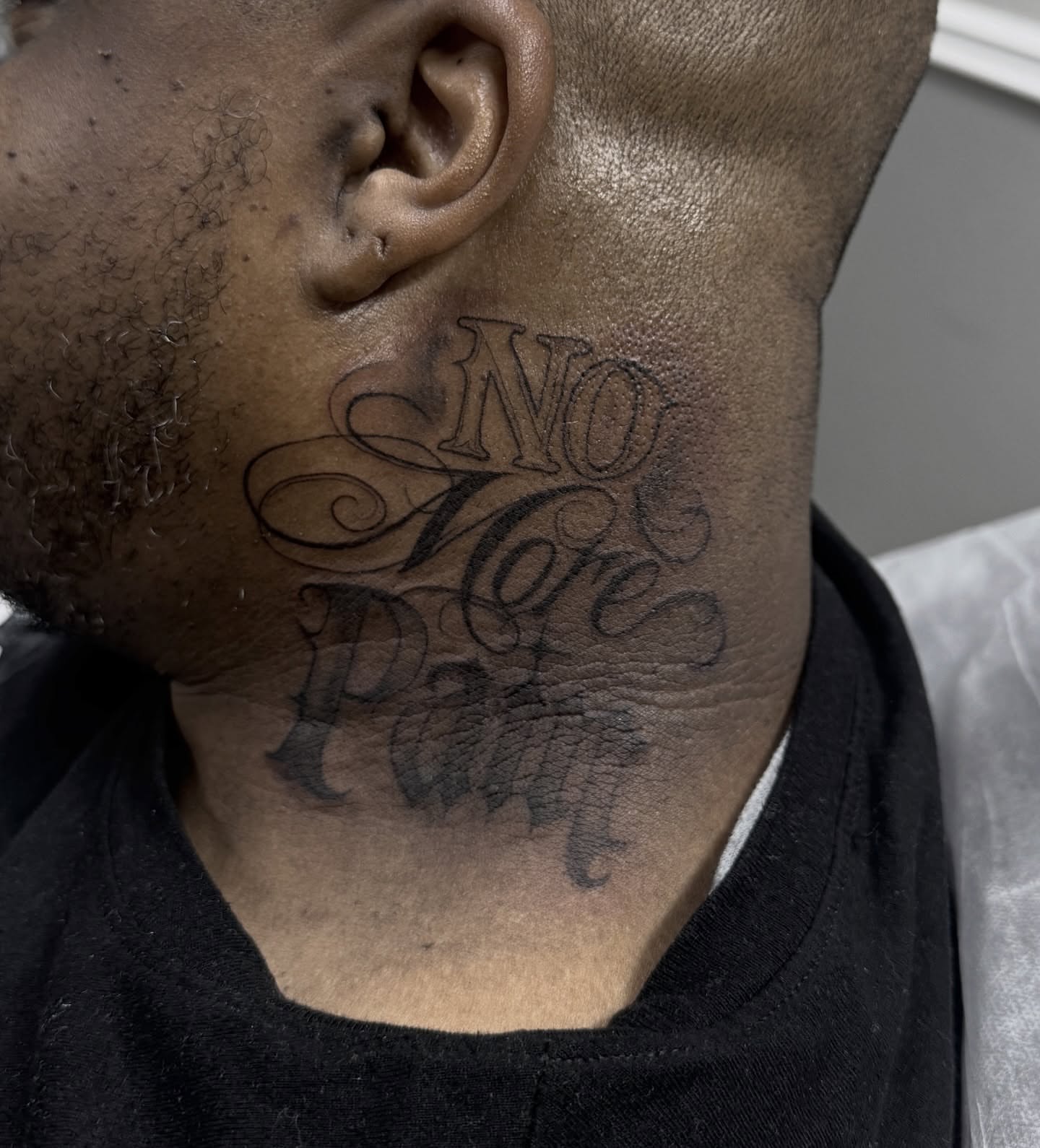 No More Pain lettering script tattoo on the neck by Mo Dinero🎰