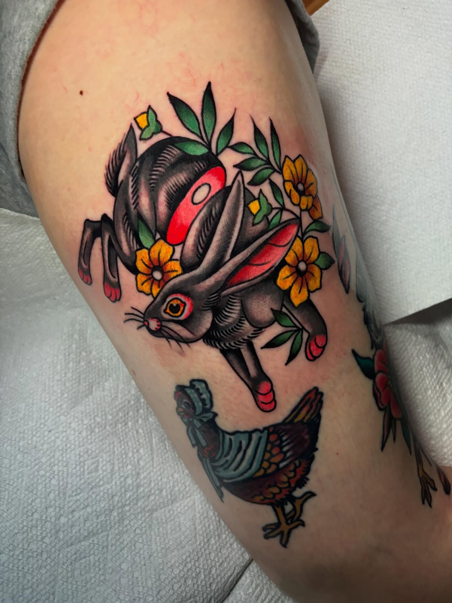 Rabbit and flowers American traditional tattoo on the forearm by Chris Dufresne