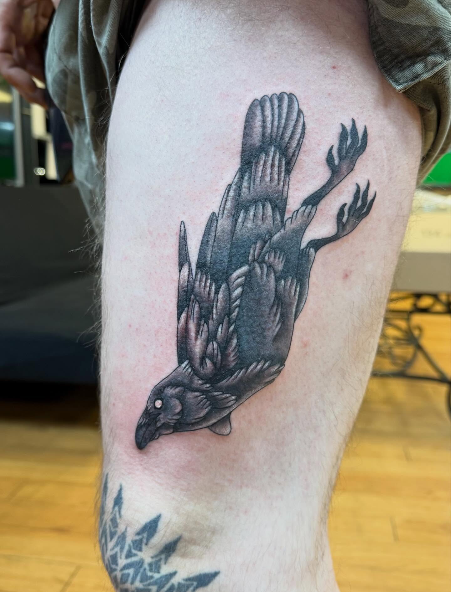 Crow black and grey tattoo on the thigh by Nic