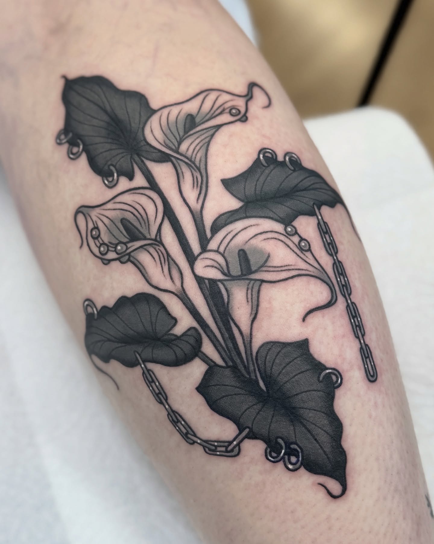 Calla lilies black and grey tattoo on the forearm by Nia (Knee-uhh) 🦷