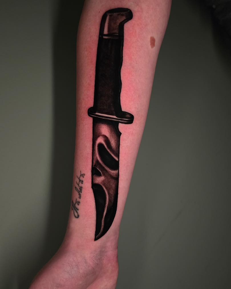 Knife black and grey tattoo on the forearm by Tank Maass