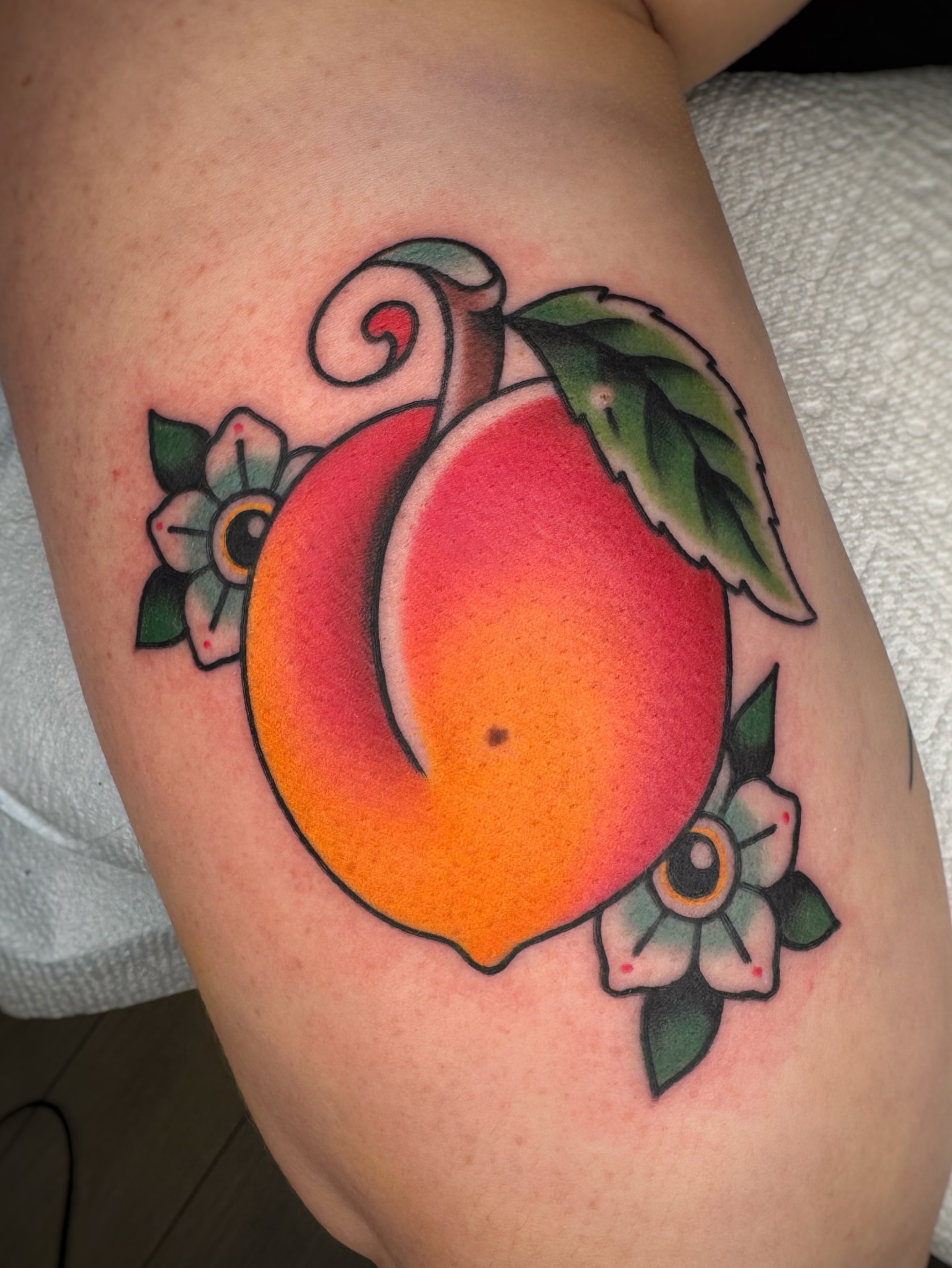 Peach American traditional tattoo on the thigh by Cori James Tattoo Artist