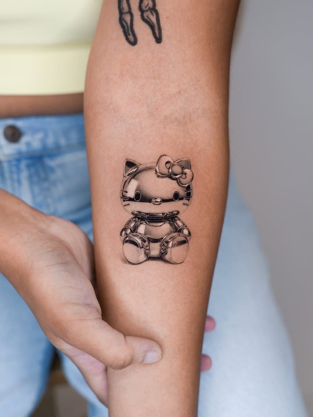 Hello Kitty robot realism tattoo on the forearm by Jun