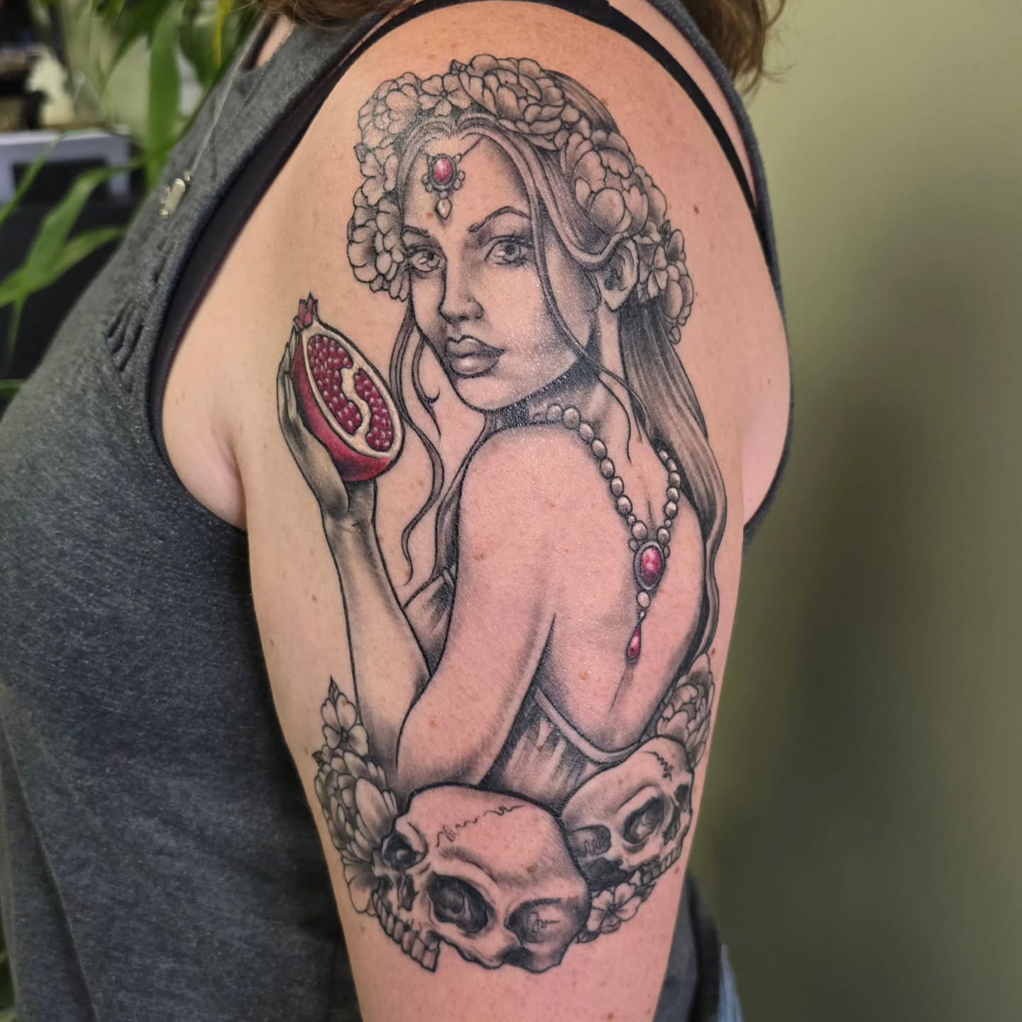 Woman with pomegranate realism tattoo on the shoulder by bonnie