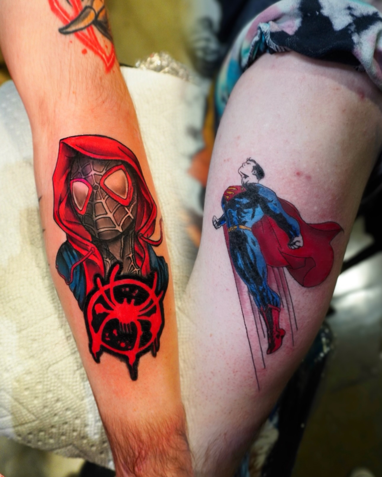 Spider-man and superman realism tattoo on the forearm by Ericka Hampton, Ferndale, Michigan