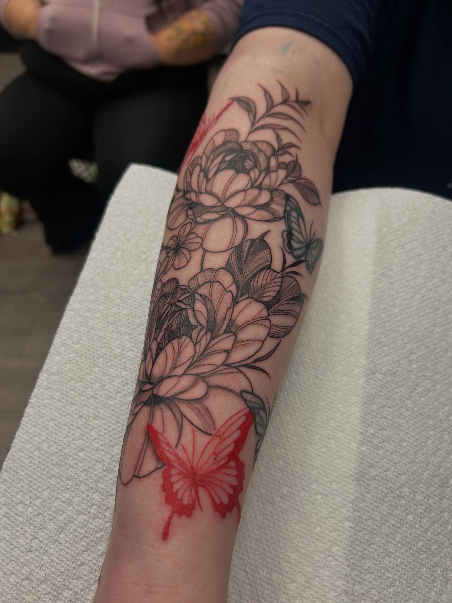 Flowers and butterflies black and grey tattoo on the forearm by Livy baby