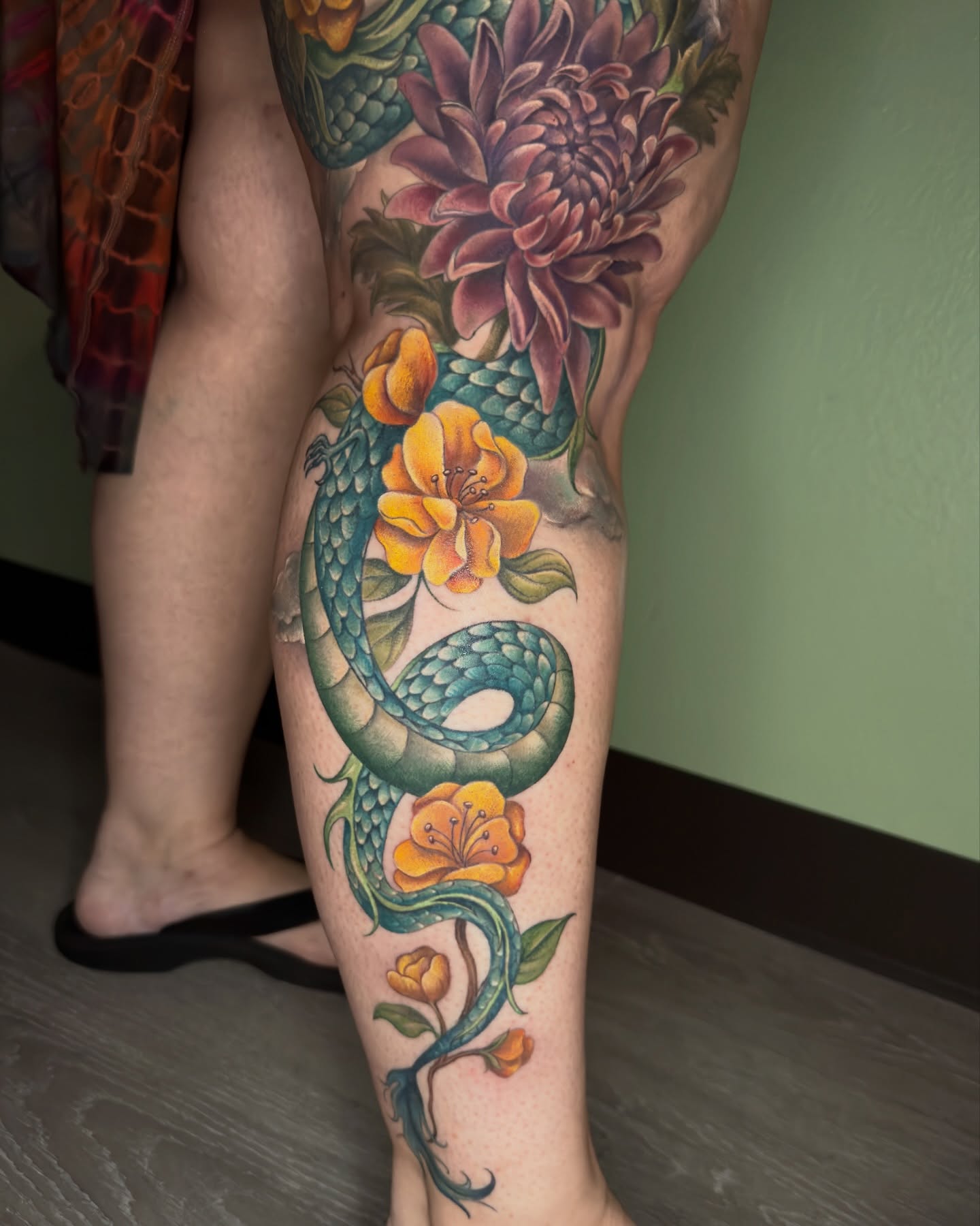 Snake and flowers new school tattoo on the leg by Nichole Lorence