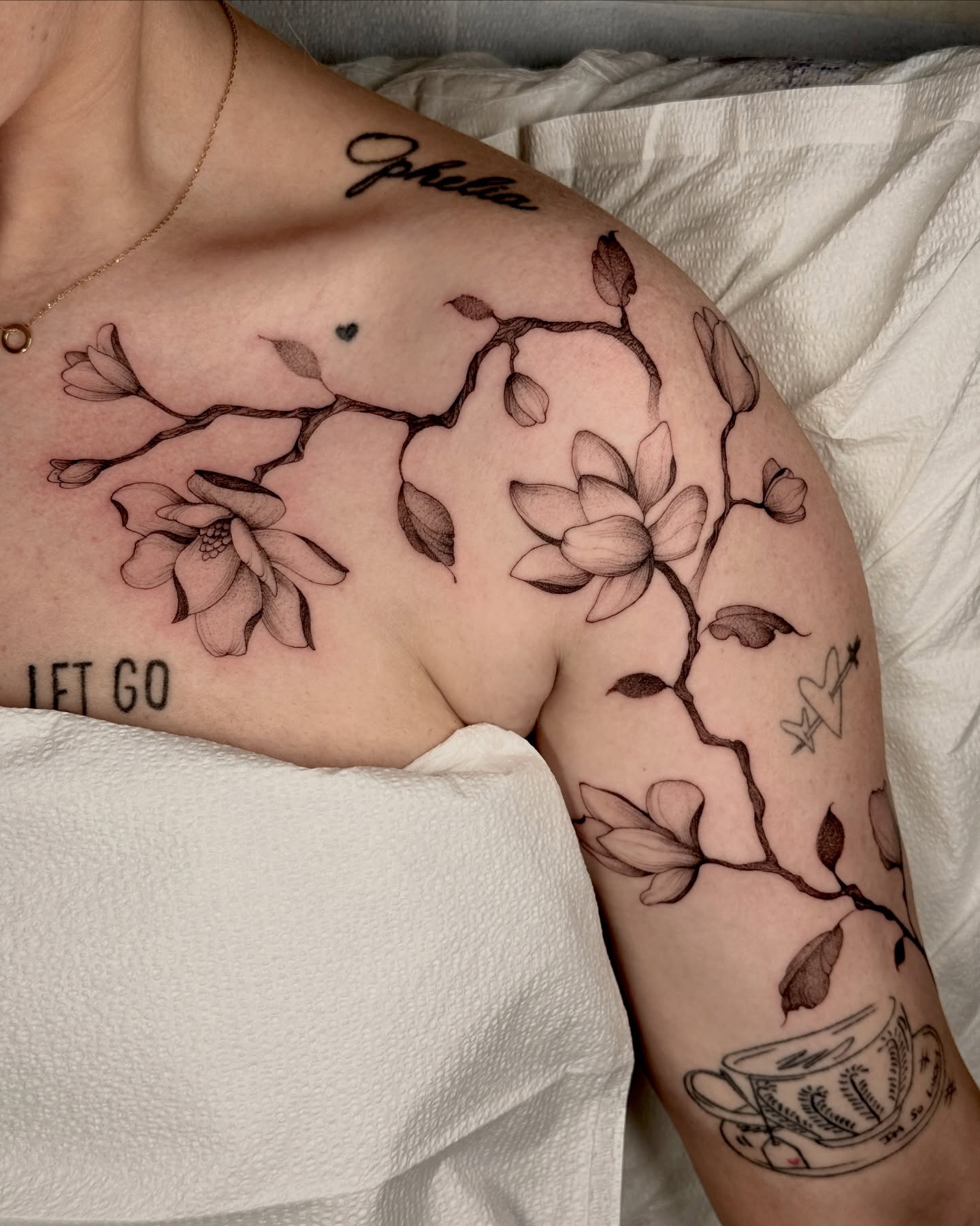 Flower branch black and grey tattoo on the upper arm by Molly Murray
