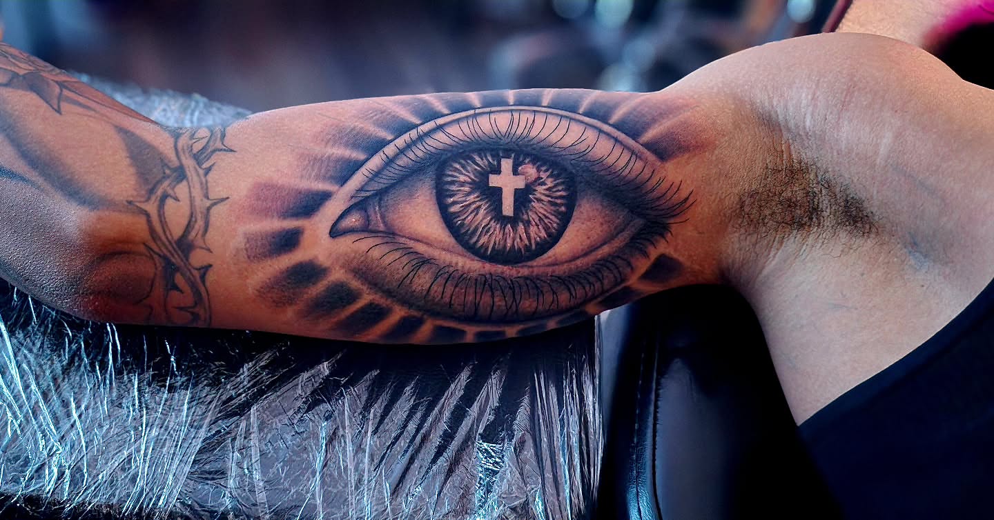 Eye with cross realism tattoo on the forearm by Luke Jordan Ink, Louisville, Colorado