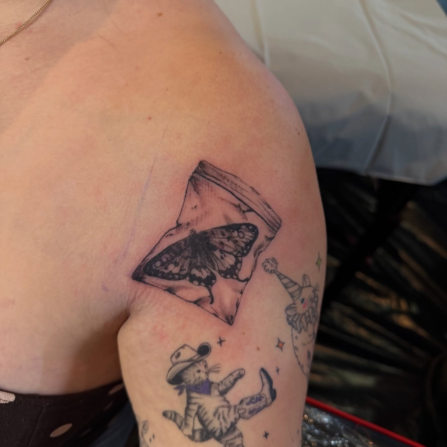 Butterfly and cat black and grey tattoo on the shoulder by Nina Nichole